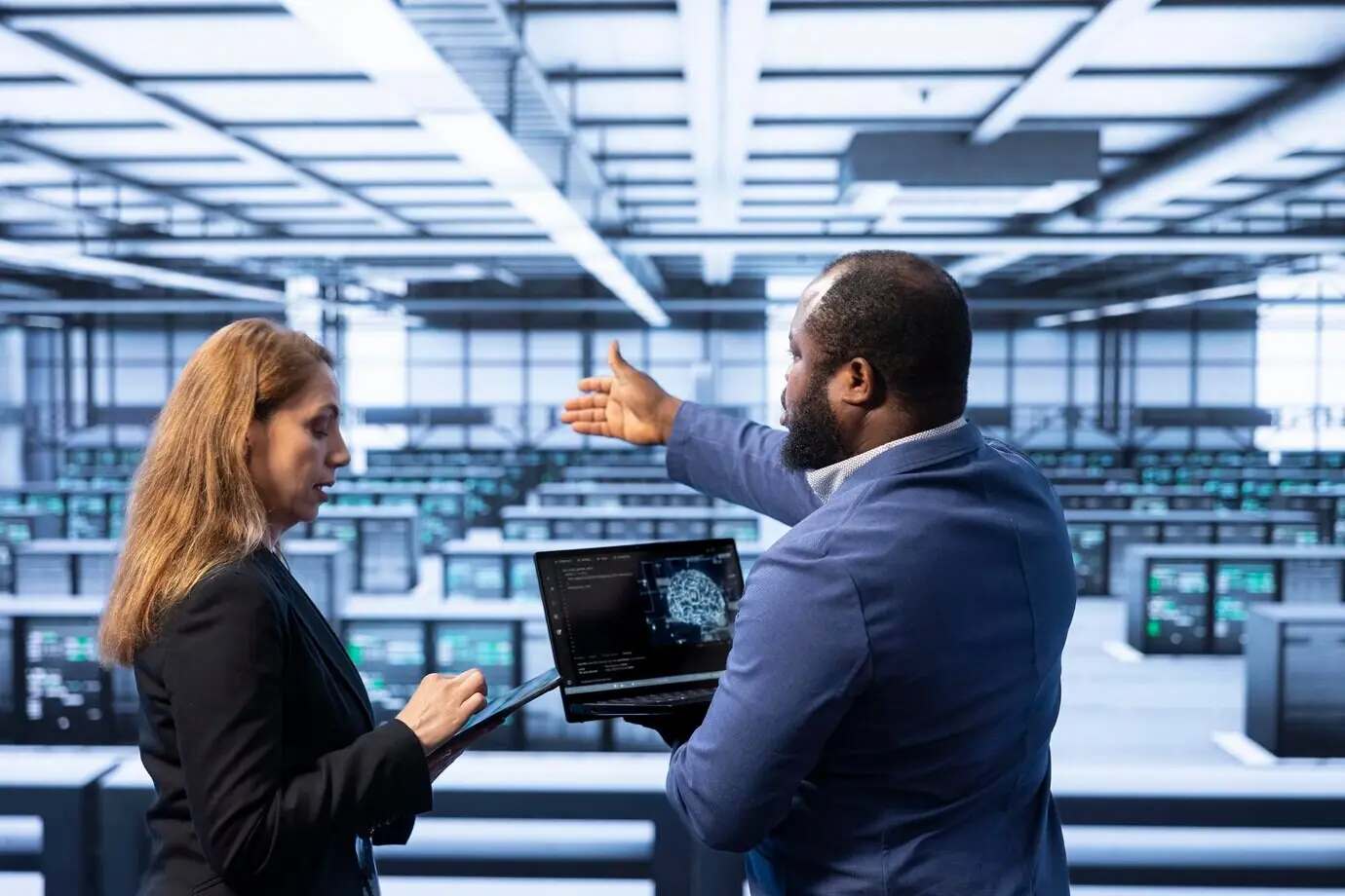 Команда техников в дата-центре использует ноутбук для визуализации ИИ.